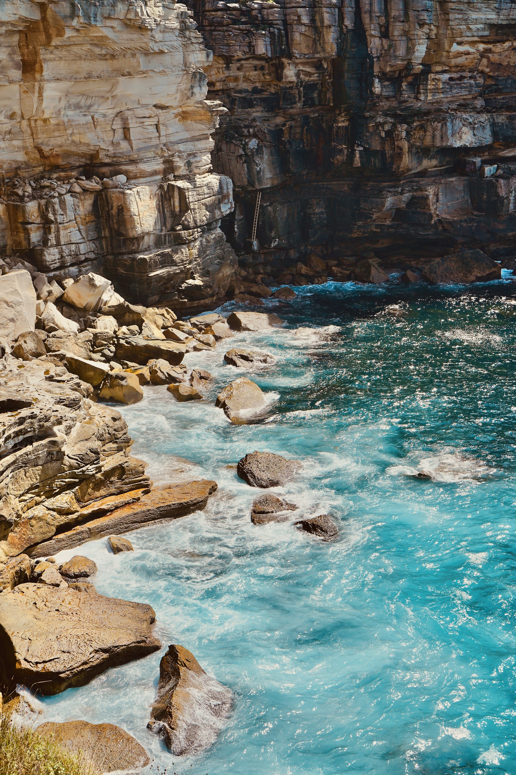 Sandstone cliffs meeting turquoise sea on the coast
